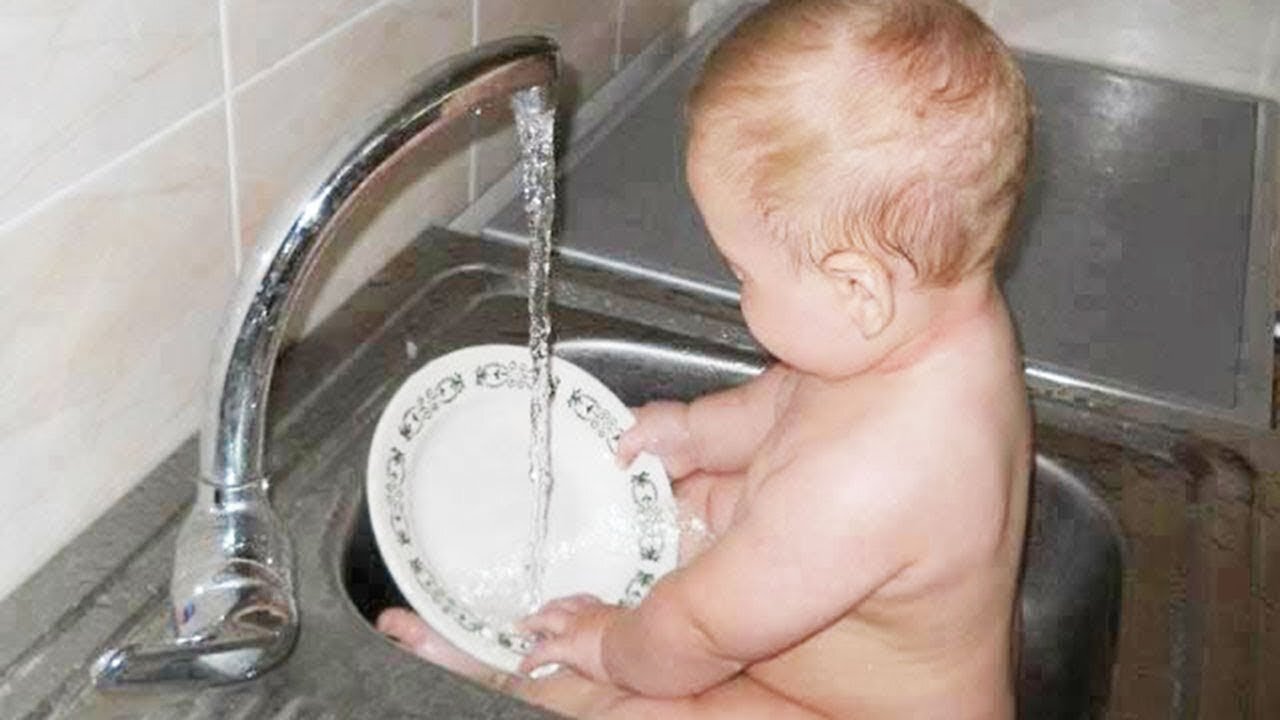 Cute baby helps her Mom to do the dishes