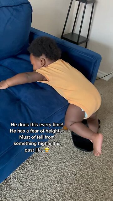 Baby holding onto couch for his life in fear of falling