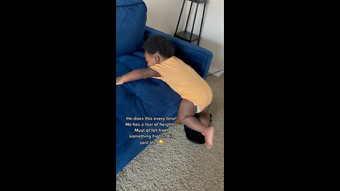 Baby holding onto couch for his life in fear of falling