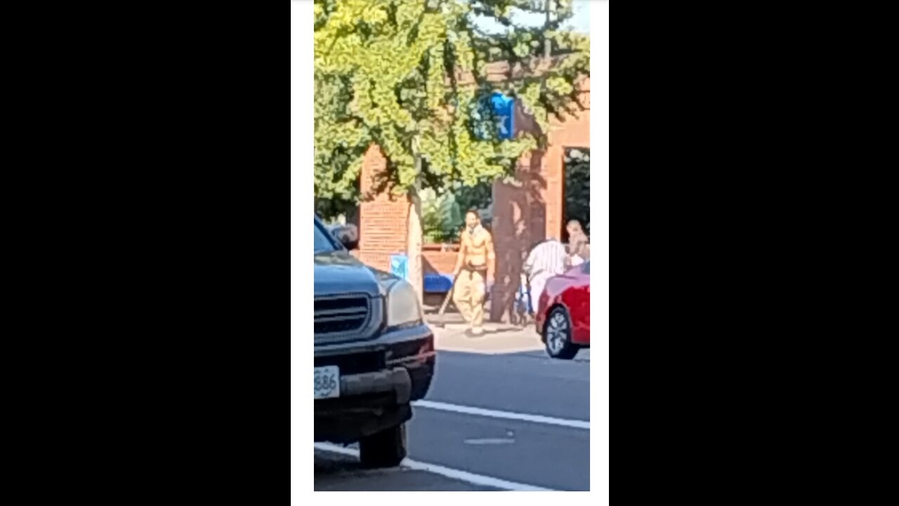 Shirtless Man Wielding Stick On Downtown Portland Sidewalk