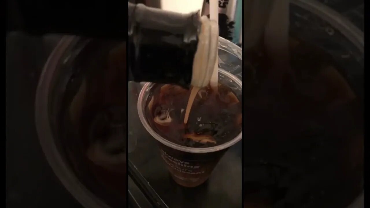 Pouring zero calorie caramel creamer into black iced coffee