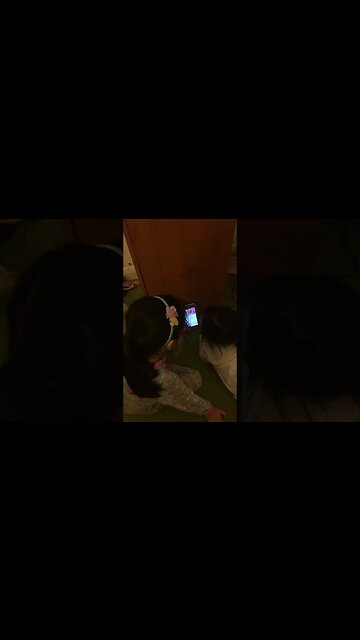 Sweet little girls are watching on daddy's phone and giggling happy