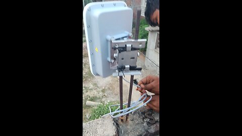 technician is carefully setting up a sleek AirFiber antenna