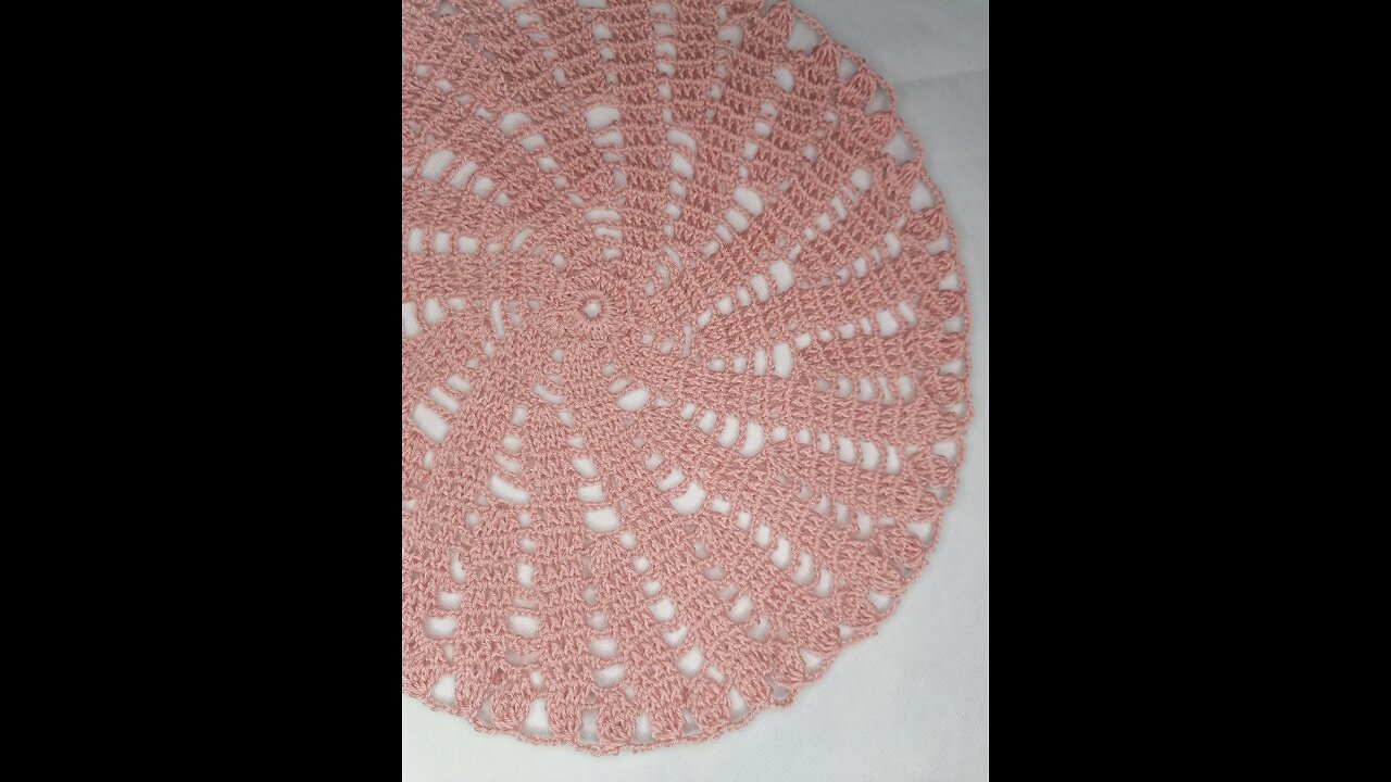 A simple and elegant circular crochet doily in the shape of a swi