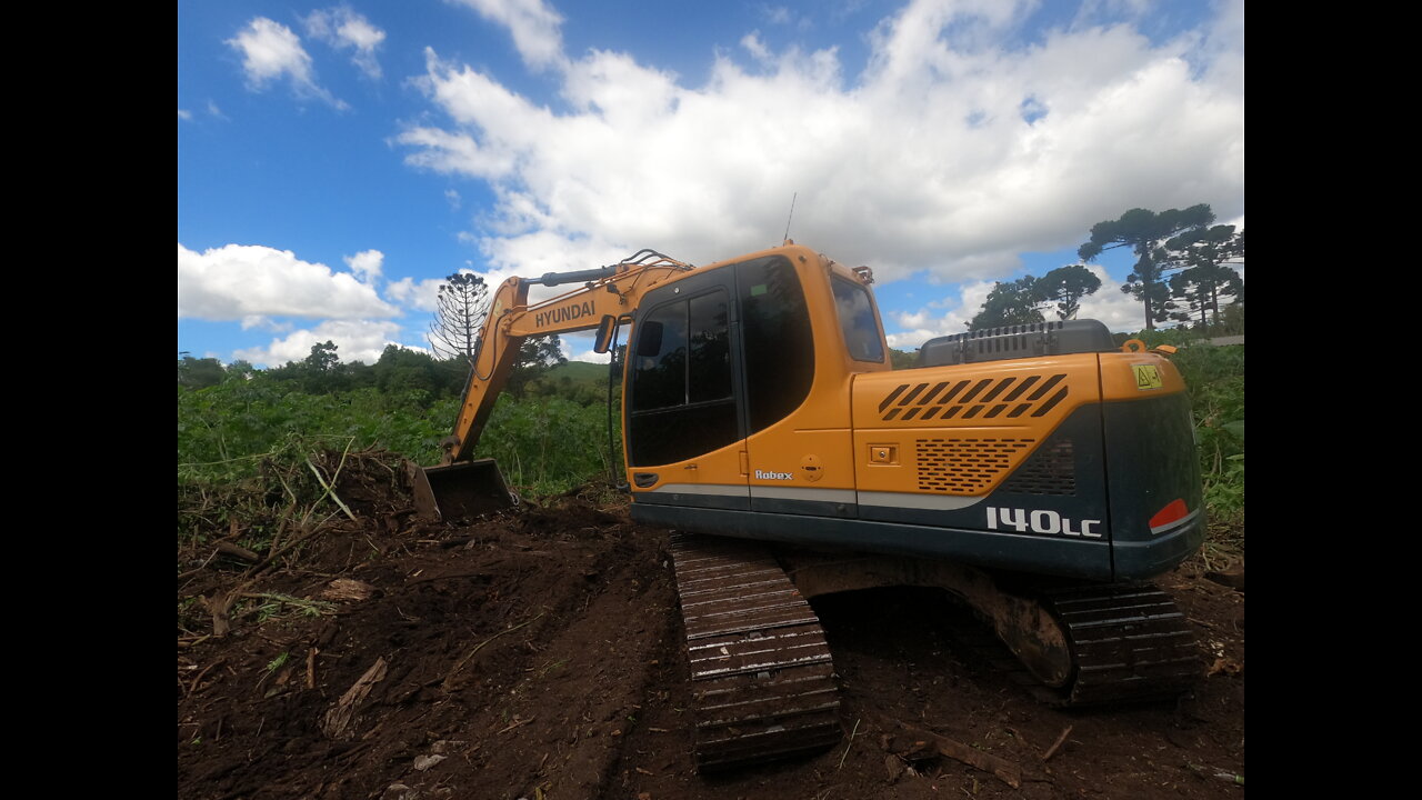 hydraulic excavator opening road in vegetation