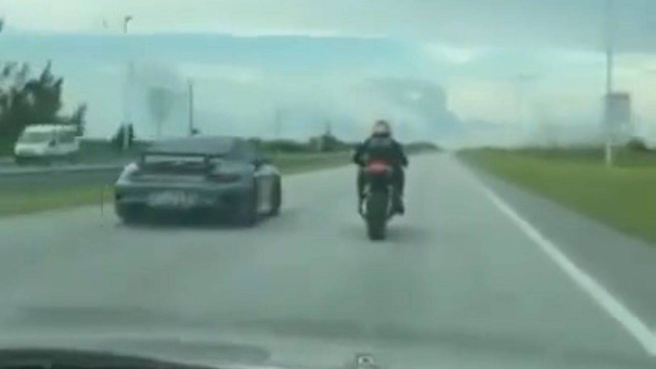 A Wise-Guy On A Motorcycle Tries To Race A Porsche, Doesn't Start Well