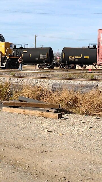 Railroad worker uses remote control to drive train and unhook rail car at the Fort Worth train yard