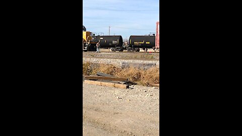 Railroad worker uses remote control to drive train and unhook rail car at the Fort Worth train yard