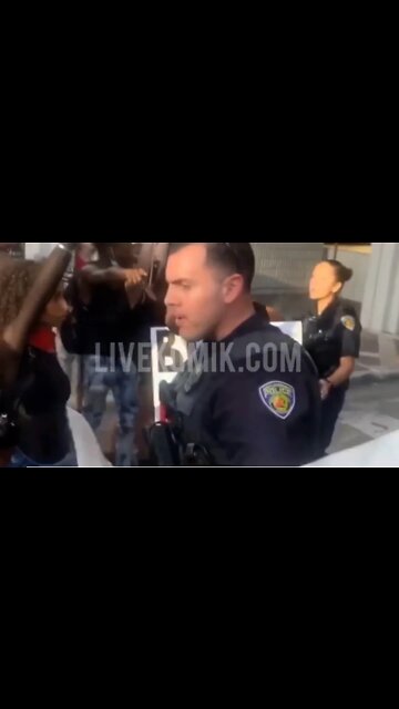 Officer seen shoving a kneeling woman during protest is suspended, police chief says