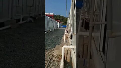 中国某地的新冠隔离区，两名全身防护服的看守人员正暴打一隔离人员。