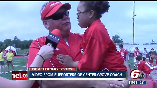 Supporters are standing behind the football coach at Center Grove High School