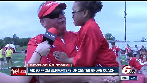 Supporters are standing behind the football coach at Center Grove High School