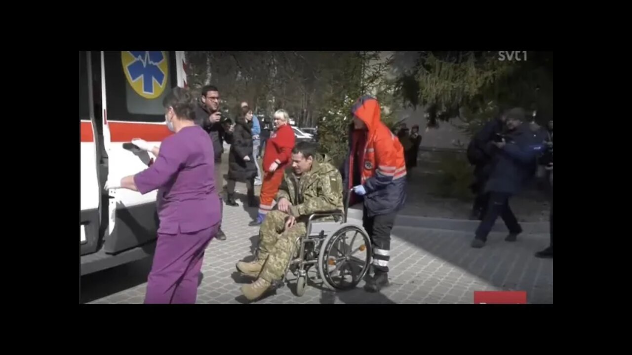 Oproportionerligt stort pressuppbåd täcker soldat i rullstol.