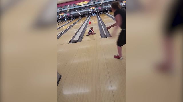 A Tot Boy Falls Down On A Bowling Lane