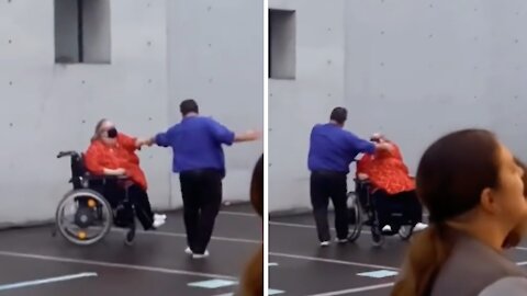 Woman in wheelchair dances with partner at concert