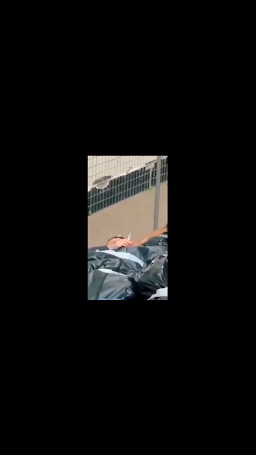 CRISIS ACTOR SMOKES A CIGGIE IN A FAKE BODY PILE