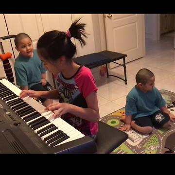 Kid Plays Piano While Her Twin Brothers Dance