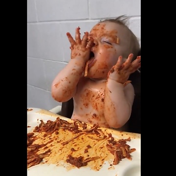 a baby trying to stay awake so he can eat his spaghetti