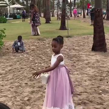 A Tot Boy Cleans Up After A Flower Girl At A Wedding