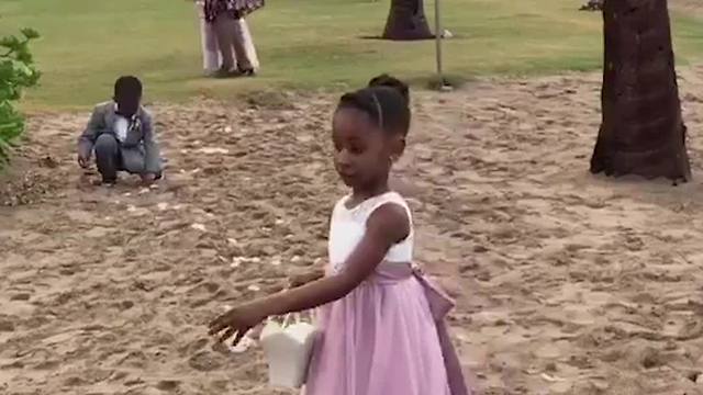 A Tot Boy Cleans Up After A Flower Girl At A Wedding