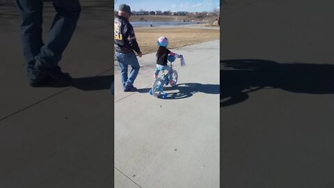 Bella rides her bicycle " I'm going fast, Grandpa!"