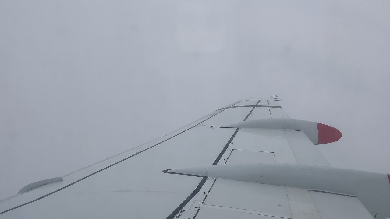 Qantas Fokker 100 breaking out of clouds