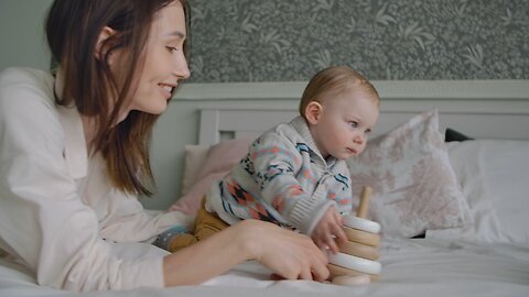 Mother and Her Son Playing on the Bed