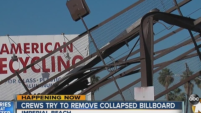 Crews try to remove billboard that nearly crashed on people