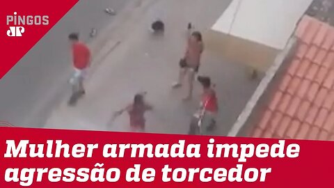 Mulher armada impede agressão de torcedor