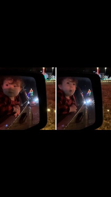 Surprised toddler in awe of Christmas lights display