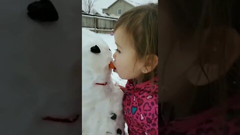 Cute innocent baby fun with snowman