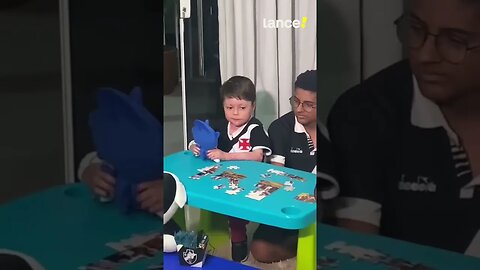 Menino Gui cantando o hino do Vasco na sua mesinha