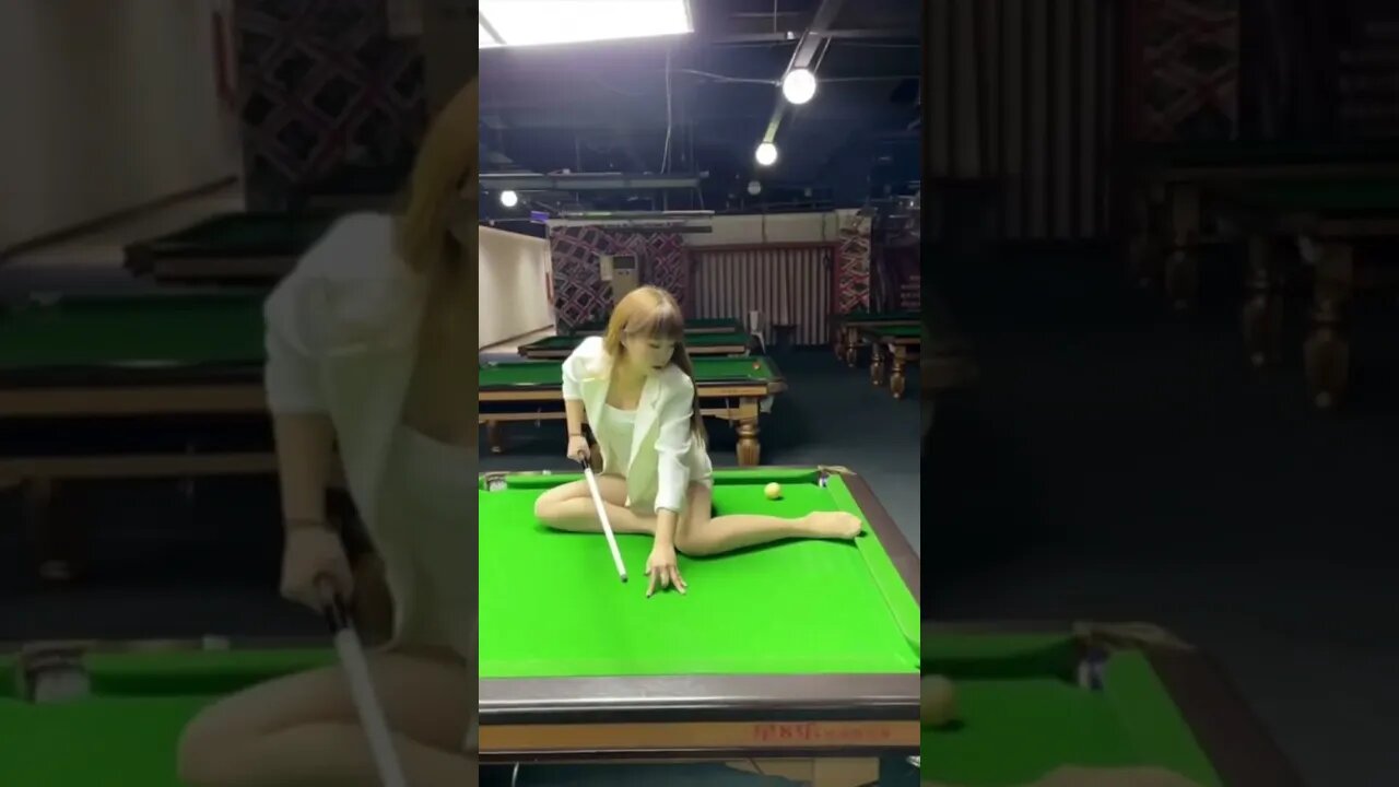 Sexy Blond Chinese Girl Sits On A Pool Table To Make A Trick Shot