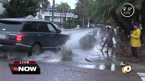 Children sprayed with water as car passes by