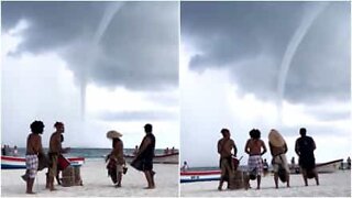 La tromba marina non spaventa i musicisti sulla spiaggia...