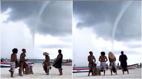 La tromba marina non spaventa i musicisti sulla spiaggia...