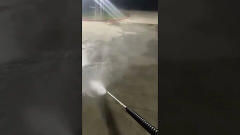 RINSING THE DIRT AWAY AFTER PRESSURE WASHING A STORE