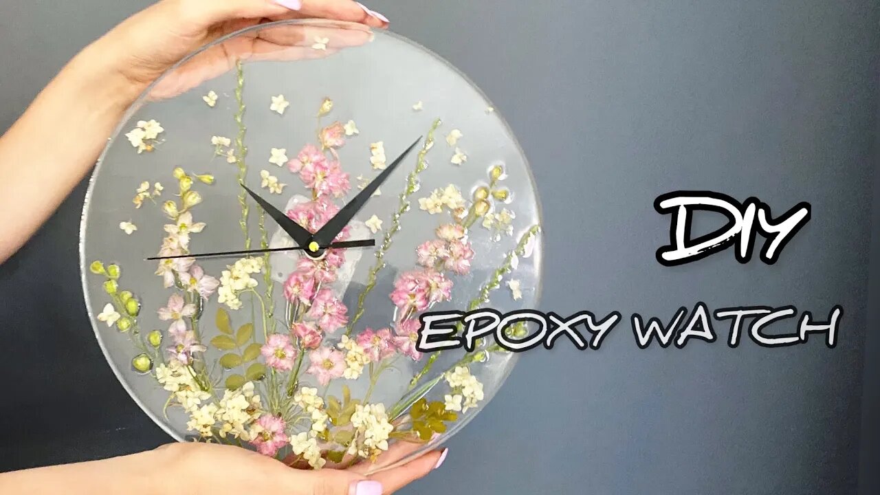 A clock with pink flowers made of epoxy resin. Watch with your own hands.