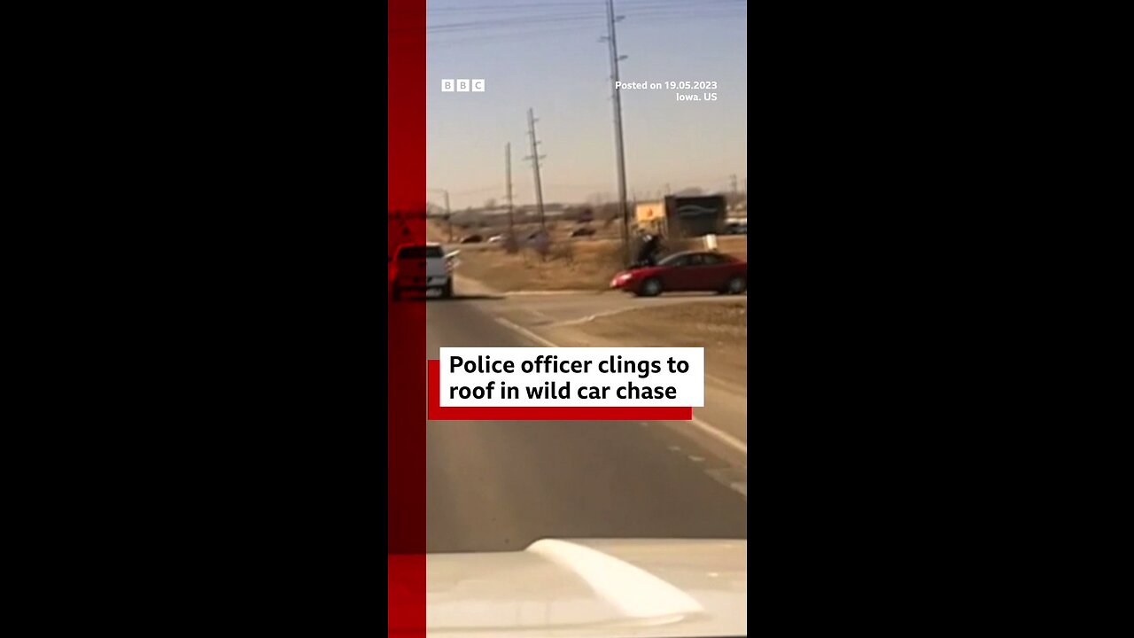 Moment police officer clings to moving car as it flees the scene in the US