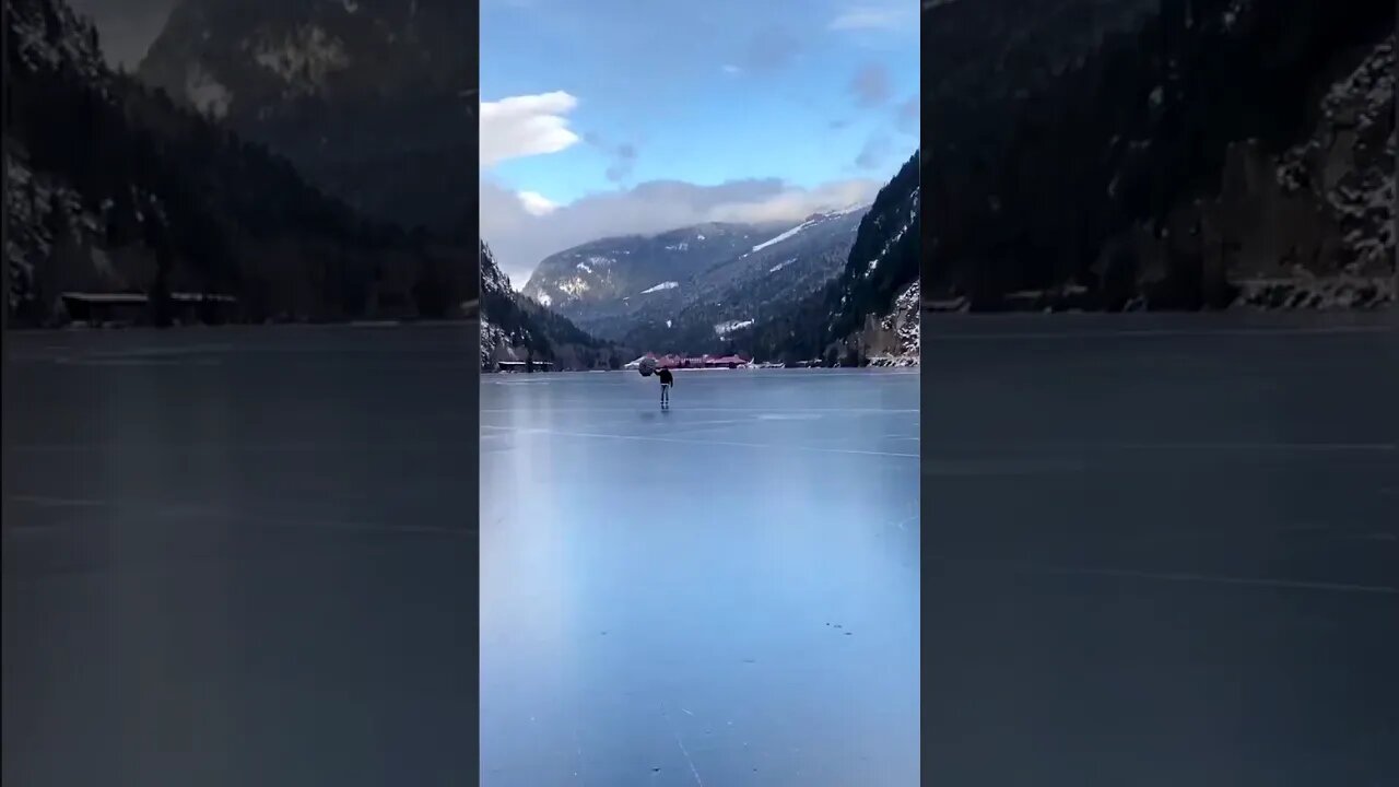 Man Travels Frozen Lake With Umbrella