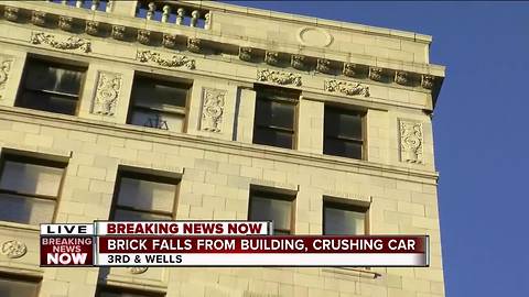 Concrete falls off downtown building, hits car