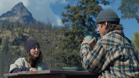 Couple drinking coffee outdoors.
