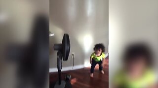 Boy Acts Like Model in Front of Fan