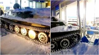 Mies varastaa pullon viiniä tankin avulla