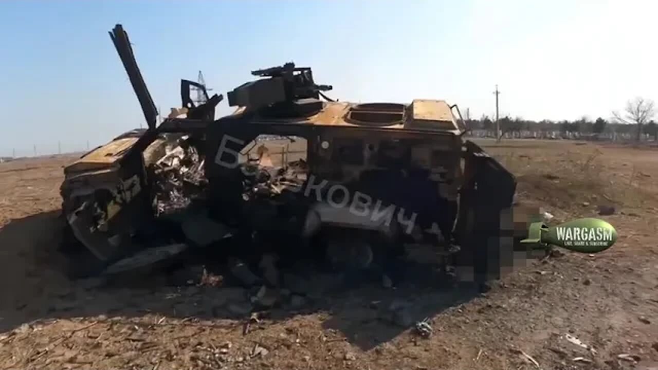 Russian soldiers inspect a burned out armored car in Zaporozhye