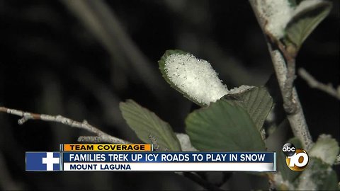 Families trek up icy roads to play in snow