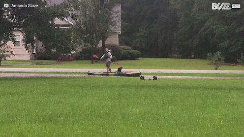 Man kayaks floodwater in garden