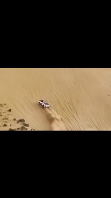 Full throttle truck drives up insanely steep sand dune