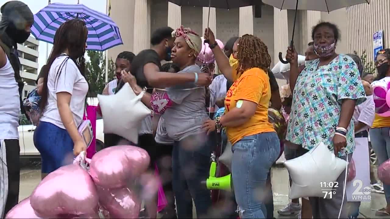 Family calls for justice through a storm outside city hall