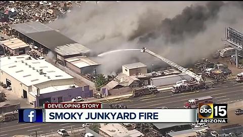 Junkyard goes up in flames, firefighter suffer overheating